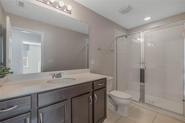 bathroom featuring vanity, walk in shower, tile patterned flooring, and toilet