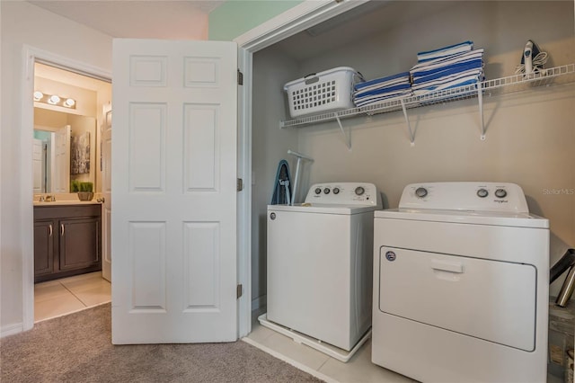 laundry area featuring sink, light carpet, and washer and dryer