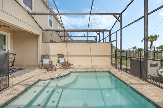 view of swimming pool featuring glass enclosure and a patio area