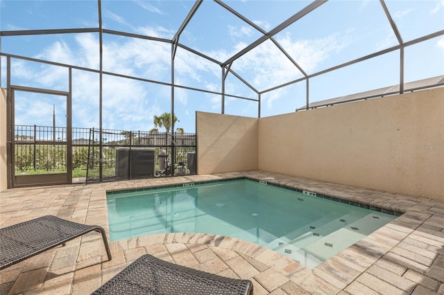 view of pool with glass enclosure and a patio area