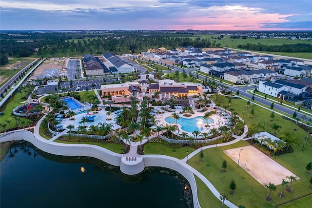 aerial view at dusk featuring a water view