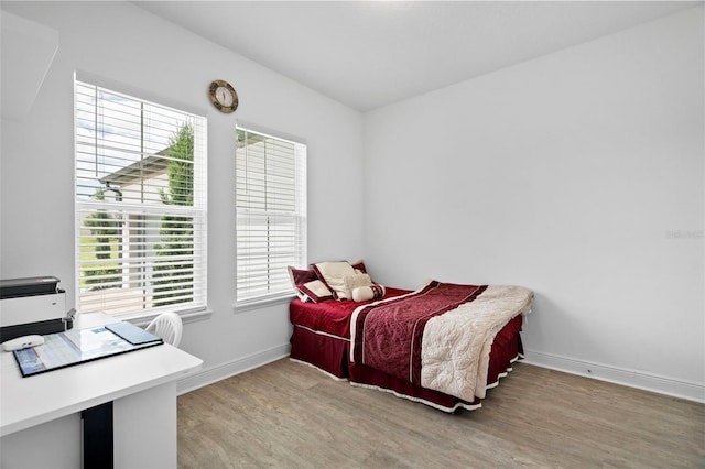 bedroom with light hardwood / wood-style floors and multiple windows