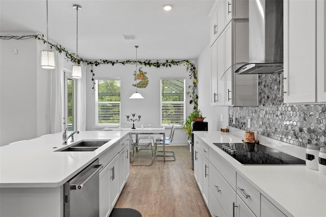 kitchen with wall chimney range hood, dishwasher, white cabinets, and black electric cooktop