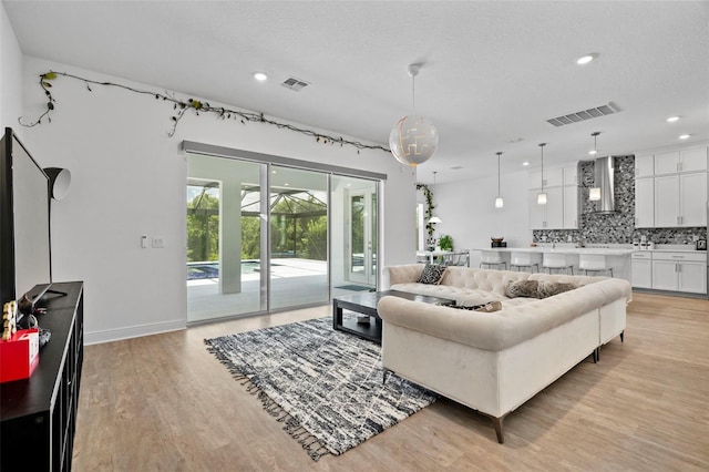 living room featuring light hardwood / wood-style floors and a textured ceiling