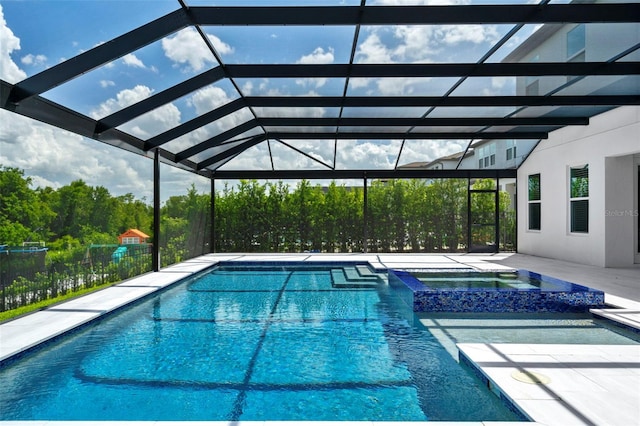 view of pool featuring a patio, an in ground hot tub, and glass enclosure