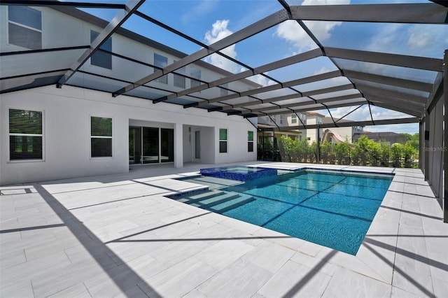 view of swimming pool with a patio, an in ground hot tub, and glass enclosure