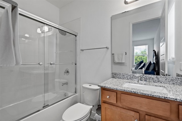 full bathroom with toilet, shower / bath combination with glass door, and vanity