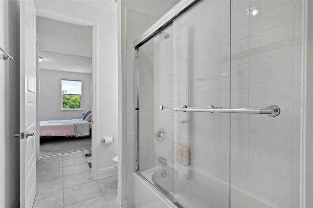 bathroom with tile patterned floors, combined bath / shower with glass door, and toilet