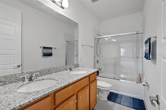 full bathroom featuring enclosed tub / shower combo, vanity, toilet, and tile patterned flooring