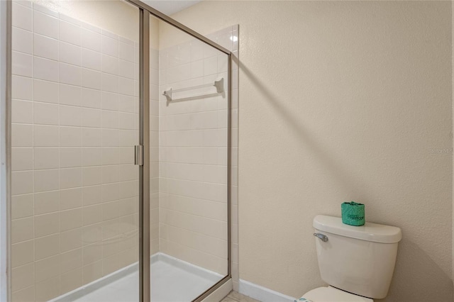 bathroom with an enclosed shower and toilet