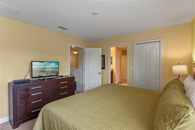 carpeted bedroom with connected bathroom, a closet, and a textured ceiling