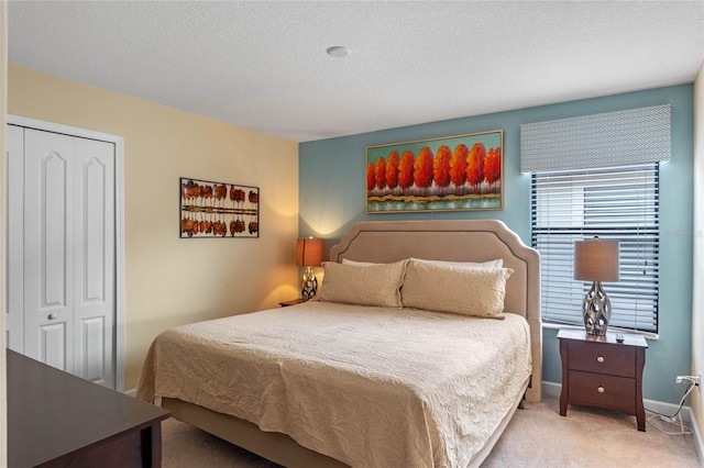 bedroom with a textured ceiling, a closet, and carpet flooring