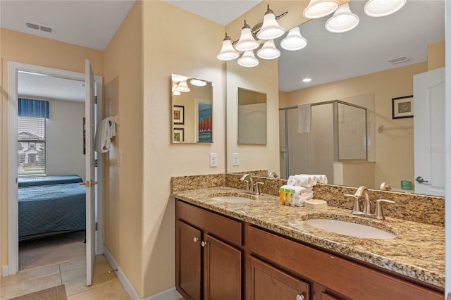 bathroom with a shower with door, vanity, and tile patterned flooring