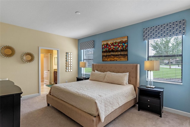 carpeted bedroom featuring ensuite bathroom