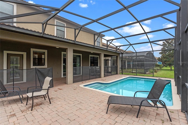 view of pool featuring glass enclosure and a patio area