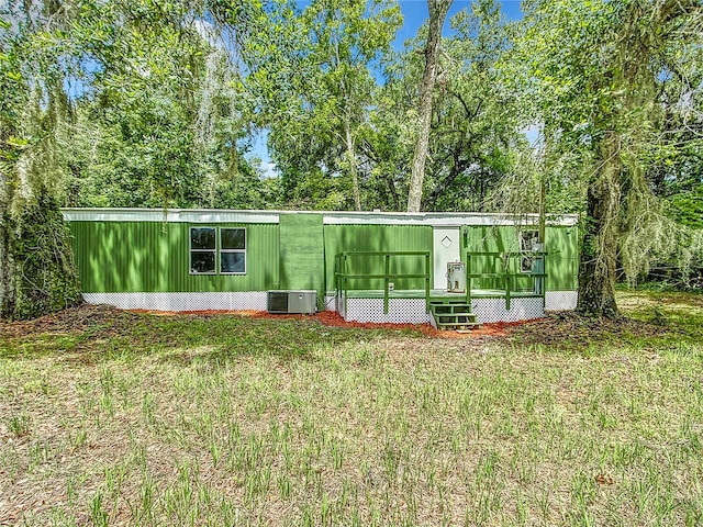 view of front of house with a front lawn and central AC unit