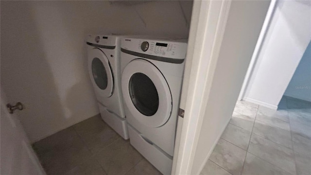 laundry room with light tile patterned flooring and washing machine and clothes dryer