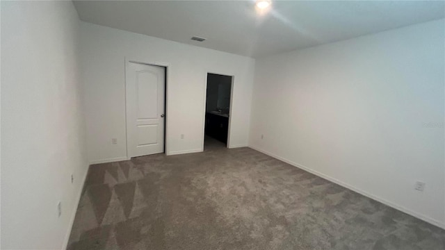 unfurnished bedroom with dark carpet