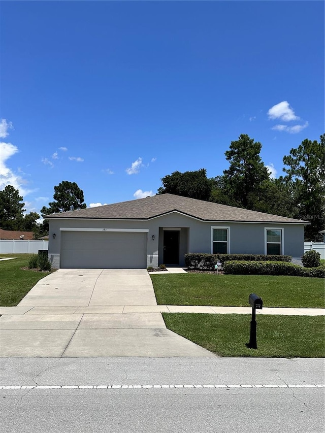 single story home featuring a garage and a front yard