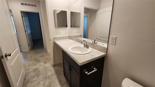 bathroom with tile patterned flooring, vanity, and toilet