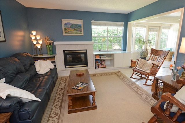 living room featuring plenty of natural light and a tiled fireplace