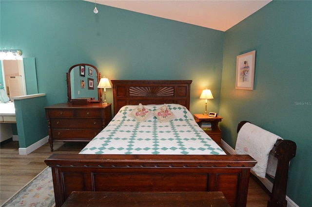 bedroom featuring hardwood / wood-style flooring and vaulted ceiling