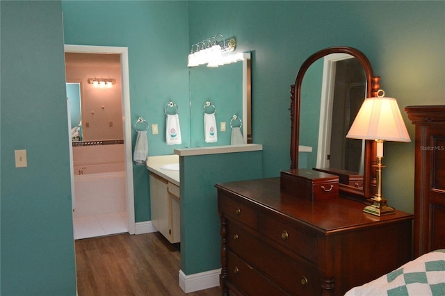 bathroom featuring a tub to relax in, vanity, and hardwood / wood-style floors