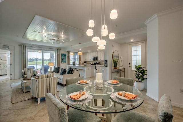 dining room with a notable chandelier, ornamental molding, and light tile patterned floors