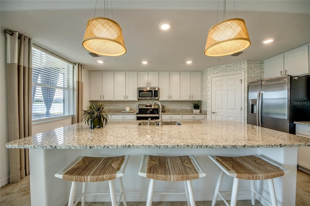 kitchen featuring hanging light fixtures, a spacious island, sink, and appliances with stainless steel finishes