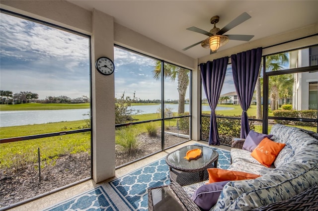 sunroom / solarium with ceiling fan and a water view