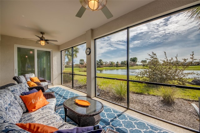 sunroom / solarium featuring ceiling fan and a water view