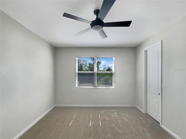 carpeted spare room featuring ceiling fan