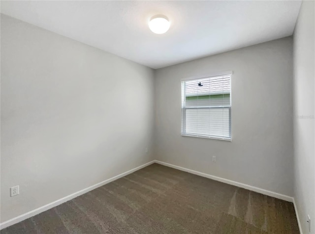 spare room with dark colored carpet