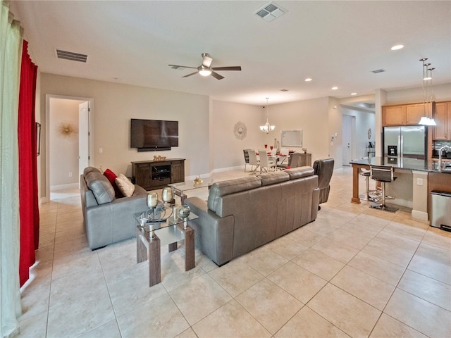 living room featuring ceiling fan with notable chandelier and light tile patterned floors