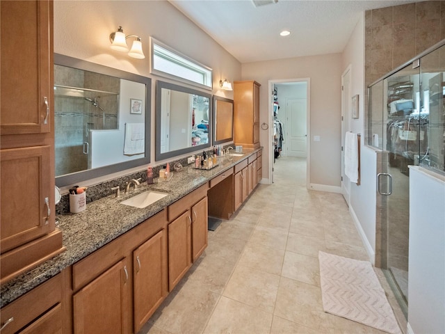 bathroom with walk in shower, vanity, and tile patterned flooring