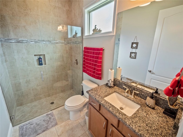 bathroom featuring a shower with door, vanity, tile patterned floors, and toilet