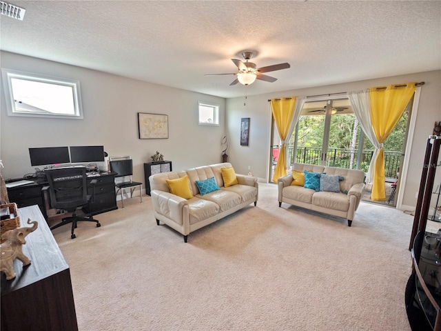 living room featuring ceiling fan, light colored carpet, and a healthy amount of sunlight