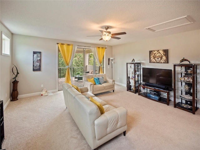 carpeted living room with ceiling fan and a textured ceiling