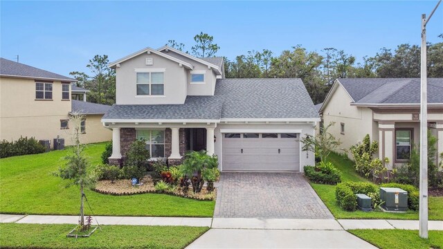 view of front facade featuring a garage, central AC unit, and a front yard