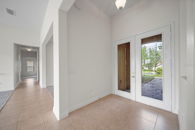 entryway with light tile patterned flooring and french doors