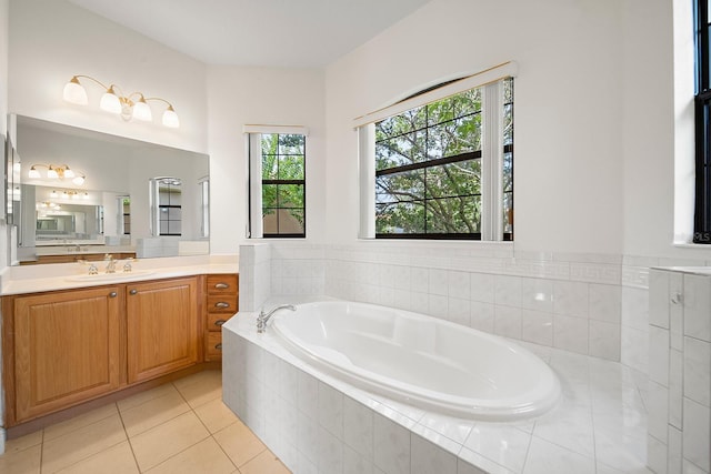 bathroom with vanity, tile patterned flooring, and tiled tub