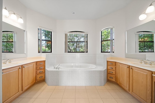 bathroom featuring vanity, tiled tub, and tile patterned floors