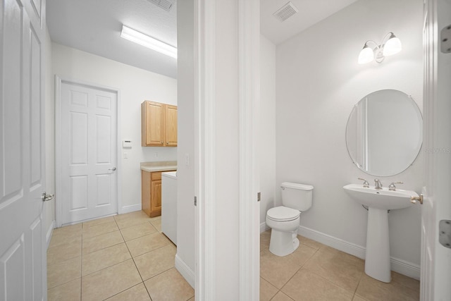 bathroom with toilet and tile patterned floors