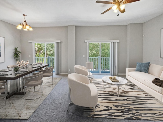 carpeted living room featuring ceiling fan with notable chandelier and a healthy amount of sunlight