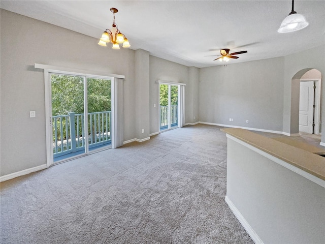 interior space with ceiling fan with notable chandelier and carpet flooring