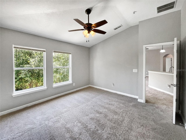 carpeted spare room featuring lofted ceiling and ceiling fan