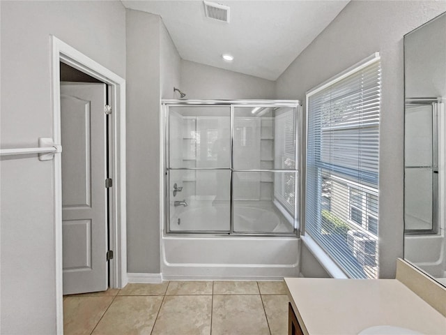 bathroom featuring tile patterned floors, vanity, enclosed tub / shower combo, and vaulted ceiling