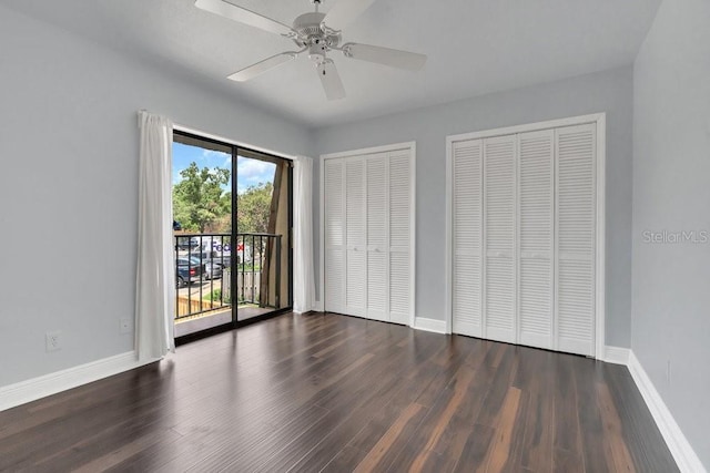 unfurnished bedroom featuring multiple closets, ceiling fan, dark hardwood / wood-style flooring, and access to outside