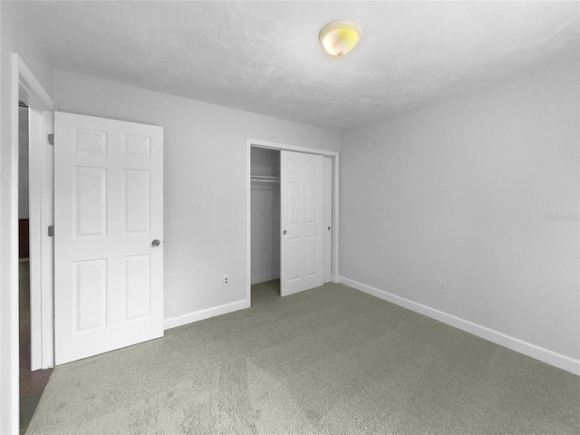 unfurnished bedroom featuring a closet and dark carpet