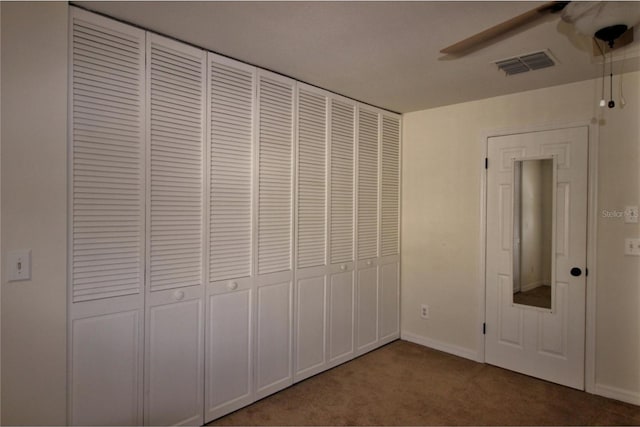 unfurnished bedroom featuring carpet, a closet, and ceiling fan